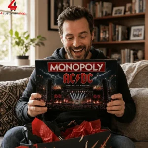 Man smiling while holding an AC/DC Collector's Edition Monopoly game box