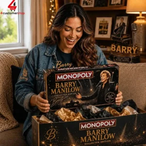 A woman enthusiastically unboxing a Barry Manilow Monopoly collector edition game.