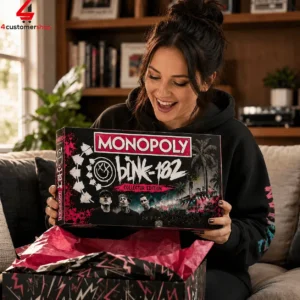 Woman opening a Blink-182 Collector's Edition Monopoly board game box.