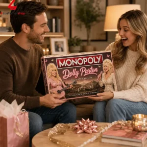 A couple excitedly opening a Dolly Parton Monopoly board game gift in a cozy living room.
