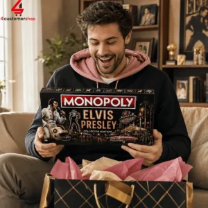 A man smiling while holding an Elvis Presley Collector Edition Monopoly game board box.