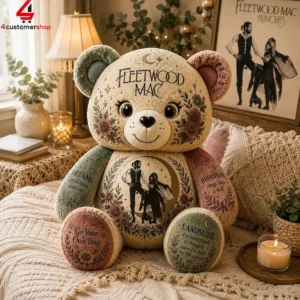A decorative Fleetwood Mac themed teddy bear featuring iconic song titles and floral artwork.