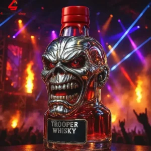 A bottle of Trooper Whisky featuring a metallic skull design with red eyes against a concert background.