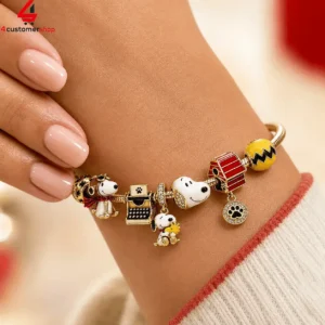 Peanuts-themed gold charm bracelet featuring Snoopy and Woodstock characters on a wrist