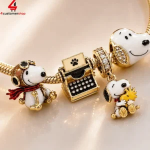 Snoopy and Woodstock gold-plated charm bracelet with detailed typewriter and aviator accessories.