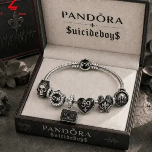 Silver charm bracelet featuring music and skull motifs in a branded display case